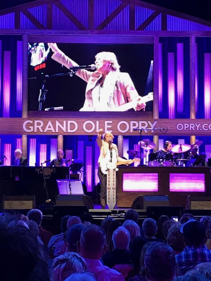 Anita Cochran on the Grand Ole Opry stage with the Opry screen behind her