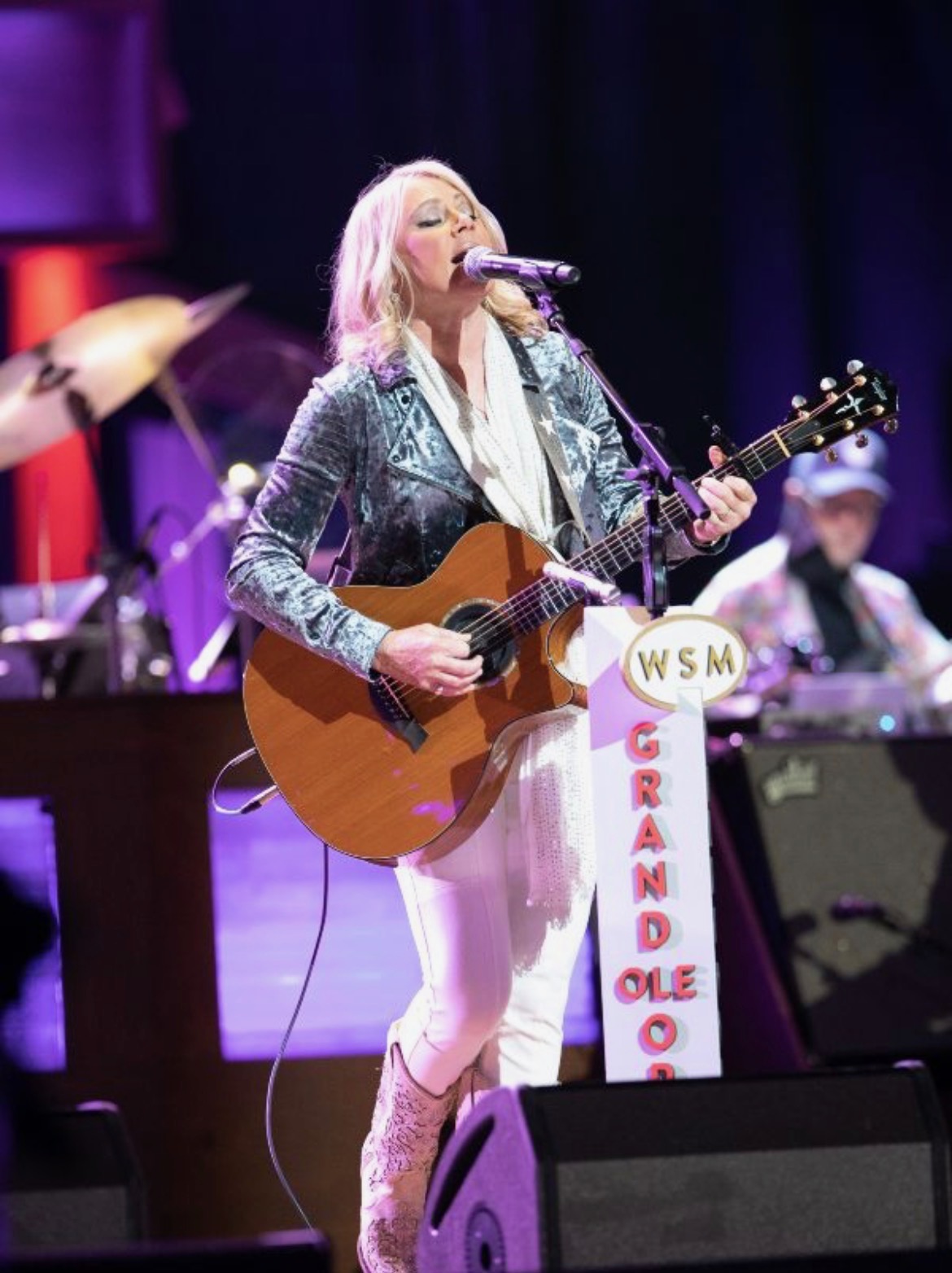 Anita Cochran singing and playing guitar on the Grand Ole Opry stage